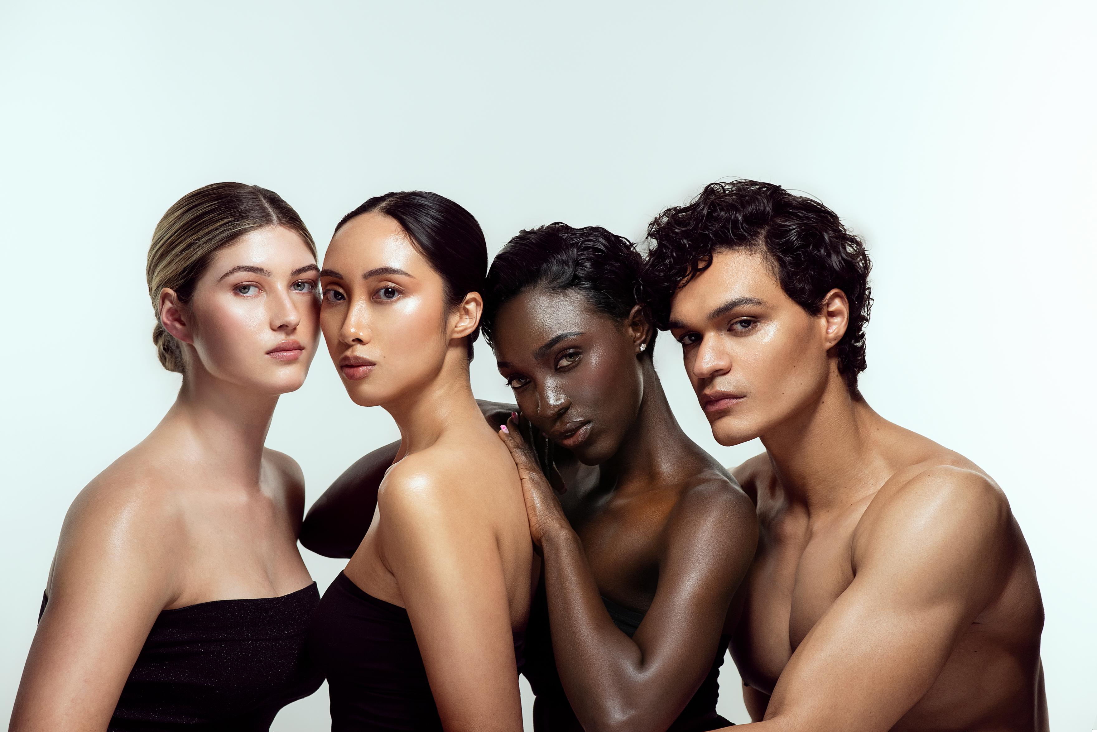 Four models with luminous skin against a pale blue background.